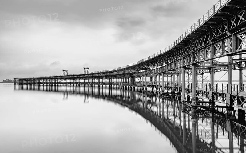 A black and white long exposure view of the historic Rio Tinto pier in Huelva