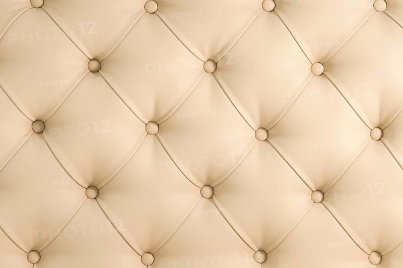 Beige soft tapestry pattern background with symmetrical buttons on the corners of diamonds. Soft and expensive furniture elements. Luxury background