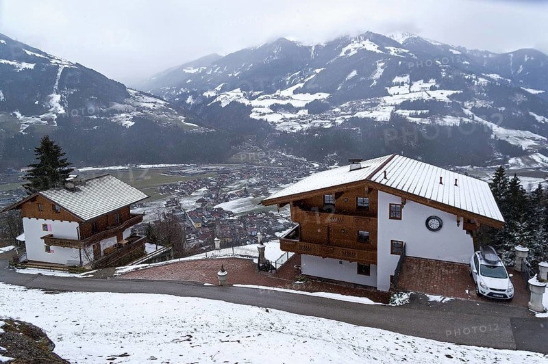 Zell am Ziller, Austria, March 11, 2019: Small apartment hotels built in Tyrolean style on the mountainside above the ski resort of Zell am Ziller. Tyrol, Austria. Cloudy day in March, Europe