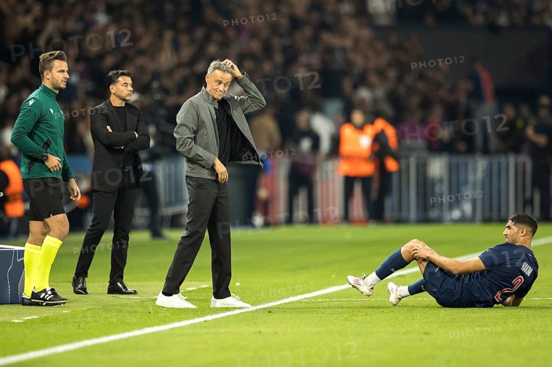 Football match, Achraf HAKIMI Paris Saint Germain right on the ground with pain in his left leg, coach Luis ENRIQUE Paris St Germain looks at him scratching his head, in the background coach MICHEL Girona FC and the fourth man on the far left, Parc des Princes football stadium, Paris