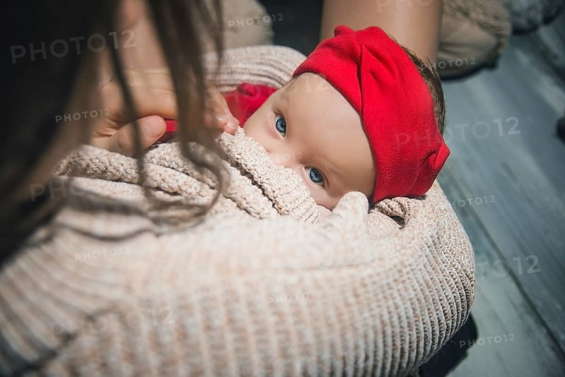 Loving Mother Cuddling Sleeping Newborn Baby daughter Over Shoulder