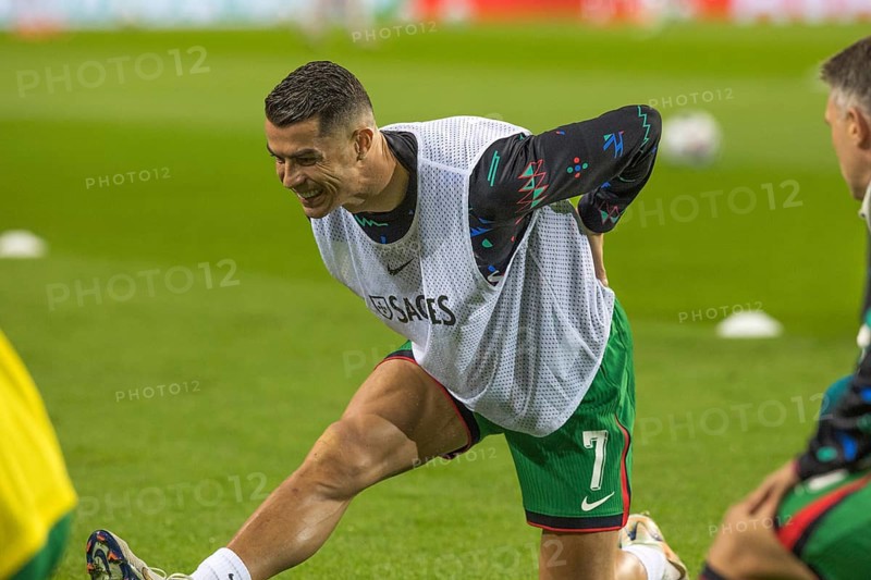 Football match, Cristiano RONALDO CR7 Portugal kneeling during pre-match warm-up with right leg and with left leg stretched out, showing teeth and looking down with concentration, Estadio do Dragao, Porto, Portugal, Europe