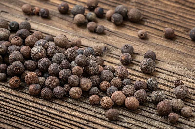 Allspice spice on dark rustic wooden background