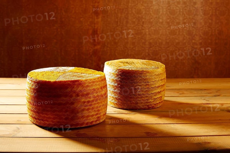 Manchego cheese from Spain in wooden table two whole pieces