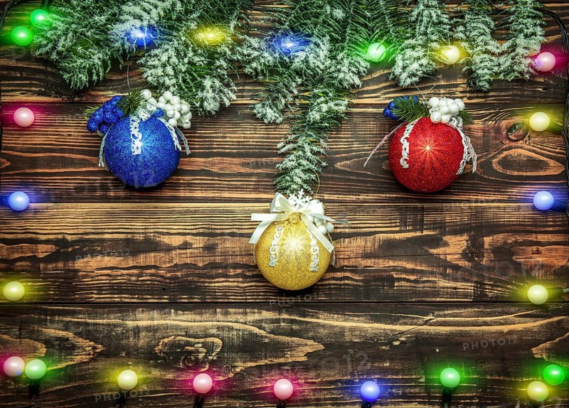 Balls and garland at fir branch on wooden background