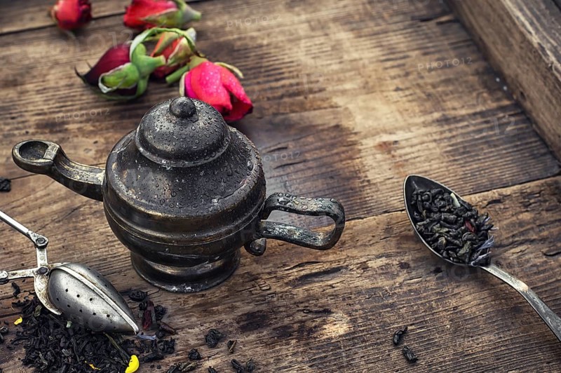 Stylish spoons with variety of tea on vintage wooden board