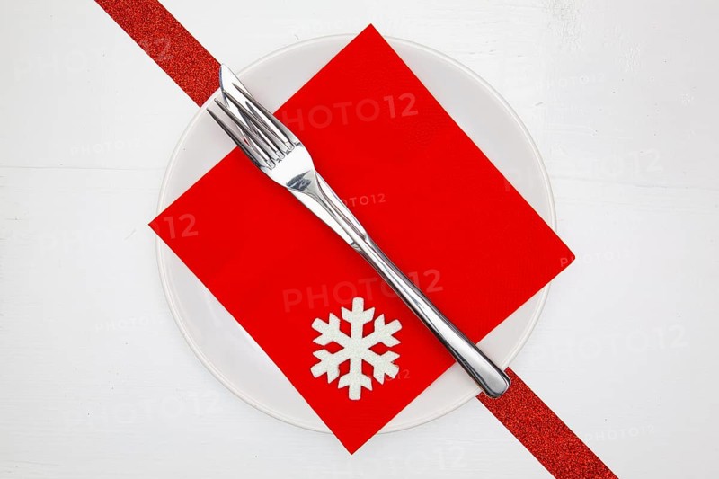 White plate and red Christmas decoration on the white wooden table.Top view.Flat Lay Image