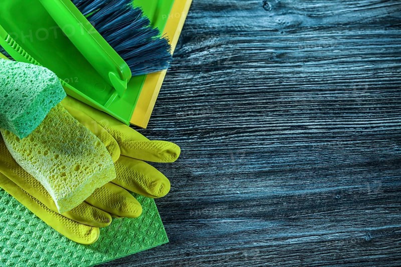 Dustpan brush sponges safety gloves dishcloth on wooden board