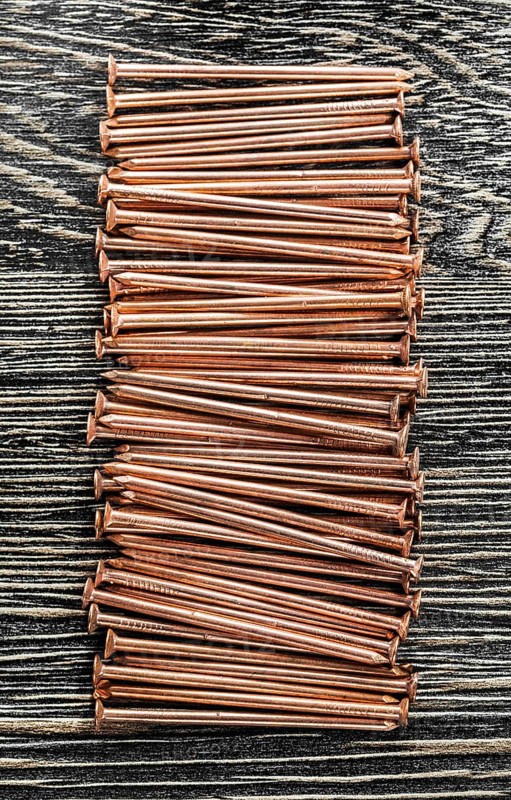 Stack of copper nails on wooden board