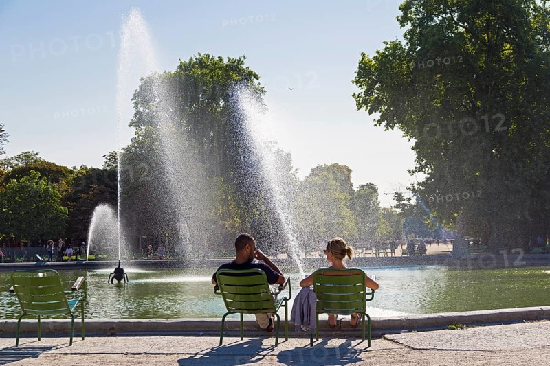 Paris, France, September 3, 2018: A man and a woman are resting by the pond in the Tuileries garden. Paris, France. A sunny day in early September, Europe