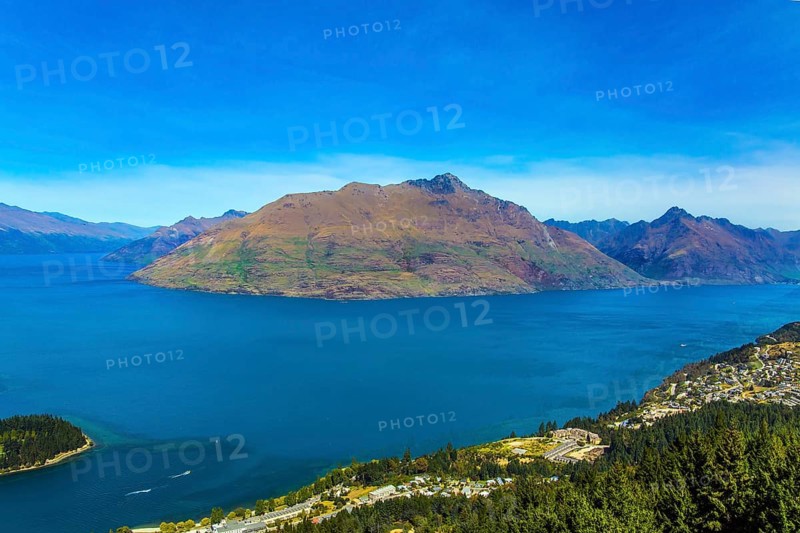 The concept of active, ecological and photo tourism. Bird's eye view. The city Queenstown, shores of Lake Wakatipu. Travel to New Zealand, South Island. Huge azure lake among the mountains