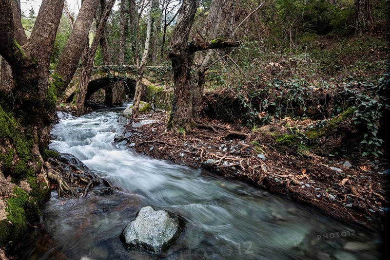 Beautiful medieval stoned bridge or Milia with river full with water flowing at Troodos mountains in Cyprus