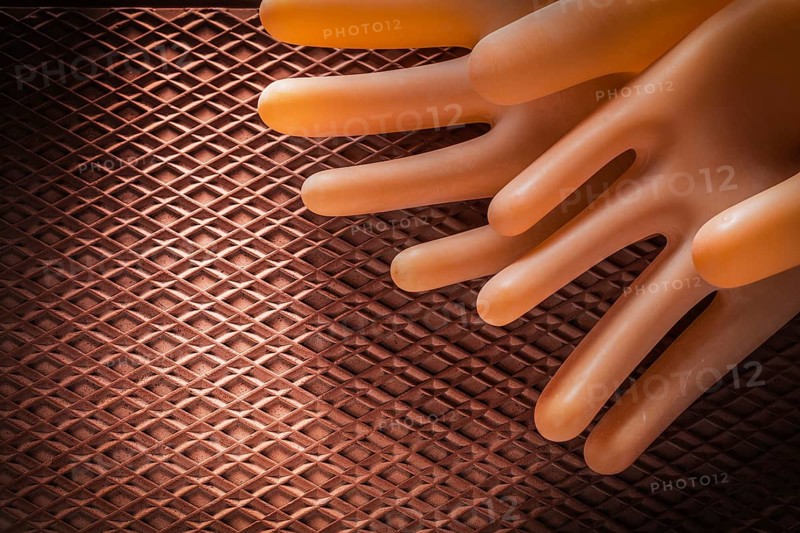 Protective insulating gloves on dielectric rubber mat