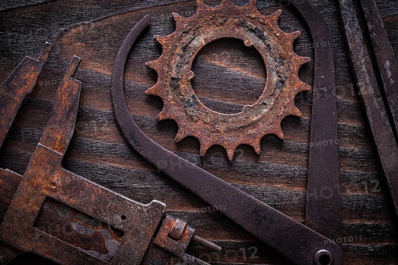 Set of rusty measuring calipers with cog- wheel on vintage dark wooden surface construction concept