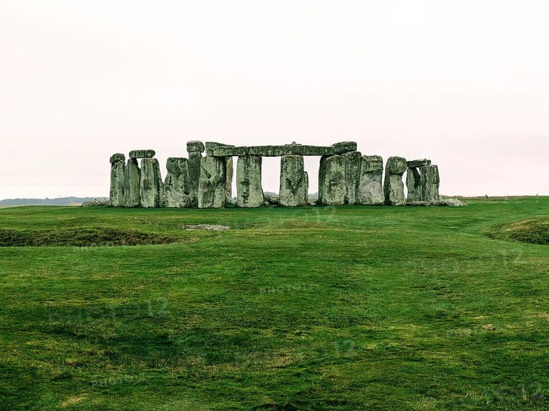 Warm-toned image of Stonehenge on a grassy field under a cloudy sky. Salisbury, England, United Kingdom, Europe