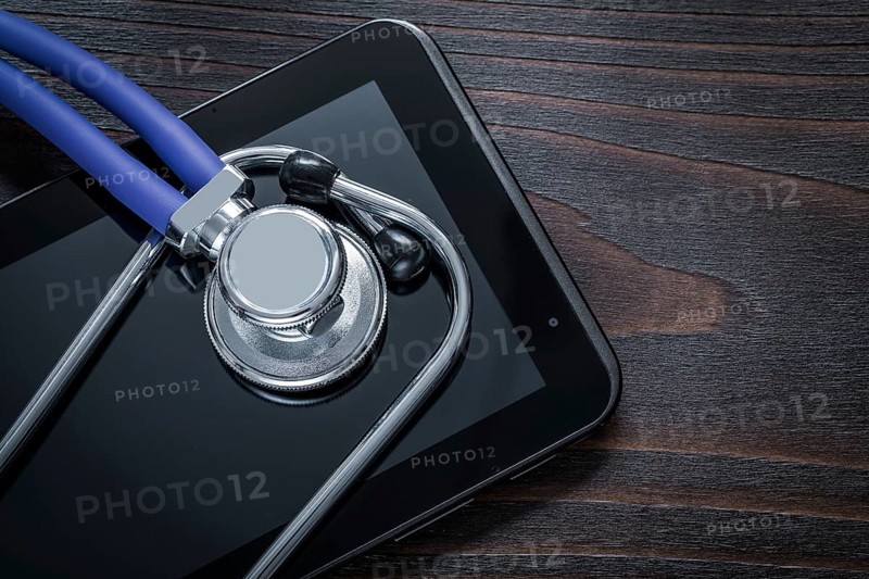 Close up of stethoscope and pad on vintage wooden background medicine concept