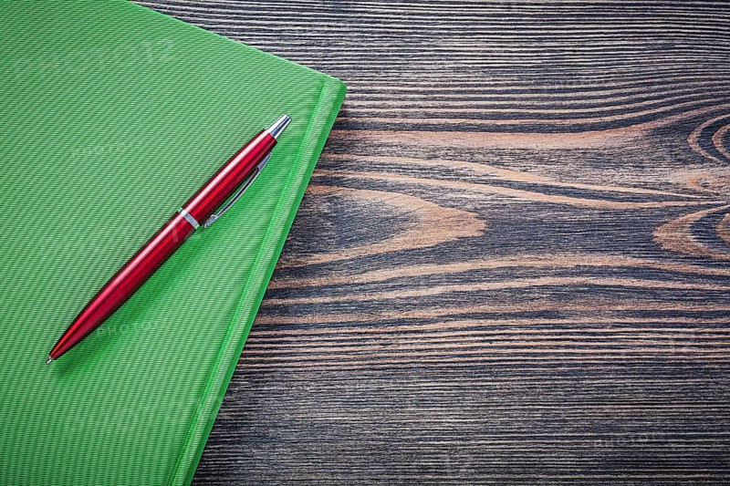Notepad brio pen on wooden board copy space