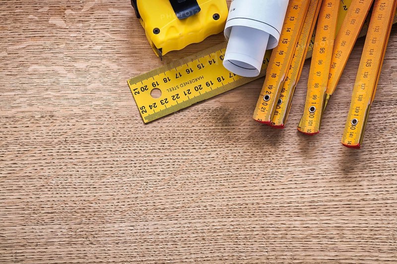 Construction plans and instruments of measurement on oaken wooden board maintenance concept