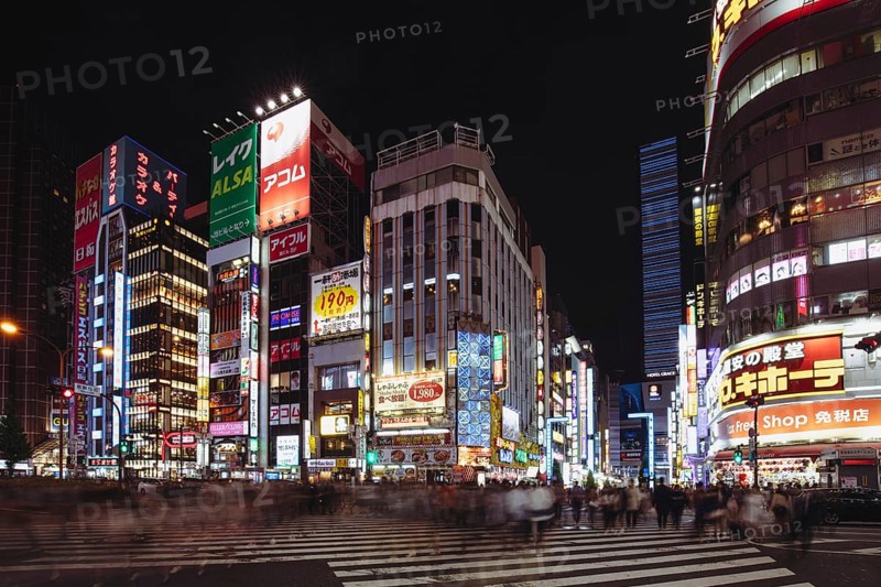 Shinjuku, Japan, May 18 2019: Neon signs illuminate Tokyo's busy Shinjuku neighborhood at night along Yasukuni-dori Ave with crowds of people, Asia