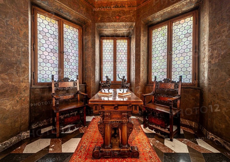Krakow, Poland, March 23, 2024, Interior of a bowed window with stained glass, luxury chairs and a carved wooden table, Europe