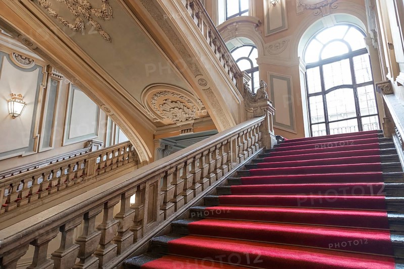 Turin, Italy, January 2023: Palazzo Barolo staircase. Luxury palace with old baroque interior and red carpet, Europe