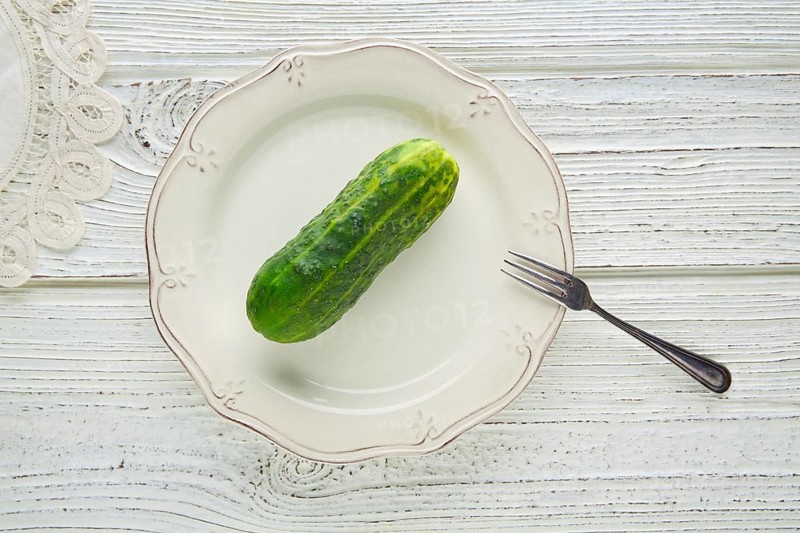 Cucumber full in white plate minimalist concept of raw vegetarian food