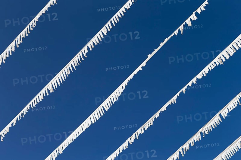 The photo shows white paper garlands with a blue sky on Majorca