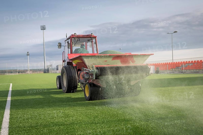 Pouring infill granules in to a football pitch with artificial grass in Lubin, Poland, Europe