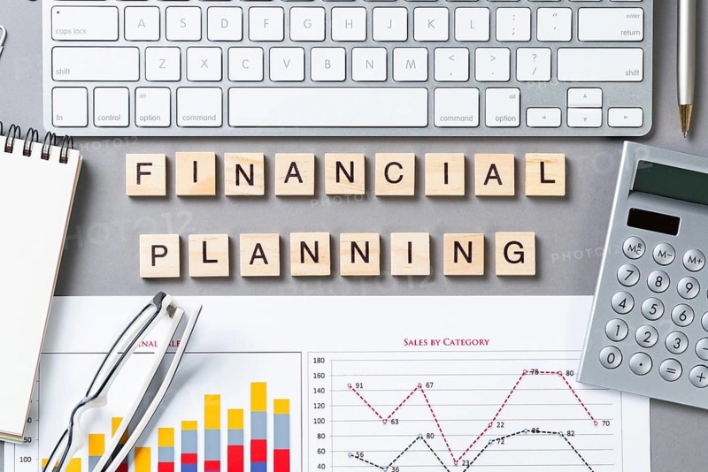Financial planning concept with letters on cubes. Still life of office workplace. Flat lay grey surface with computer keyboard, calculator and analytic report. Company development and consulting