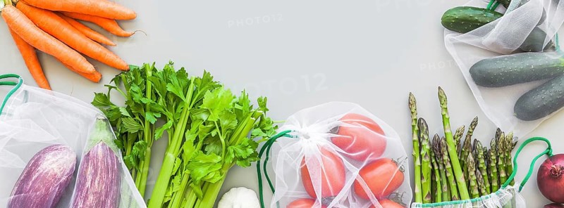 Fresh organic vegetables in eco reusable produce shopping bags flat lay, top view with copy space on gray background. Sustainable lifestyle. Zero waste, plastic free concept