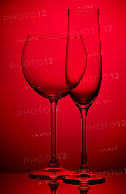 Two empty wineglasses on a red background