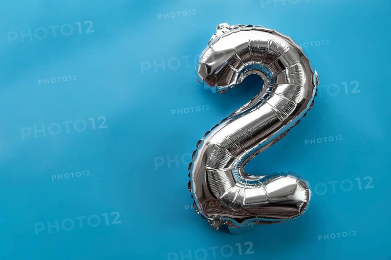 2 two metallic balloon isolated on blue background. Greeting card silver foil balloon number Happy birthday holiday concept. Copy space for text. Celebration party congratulation decoration