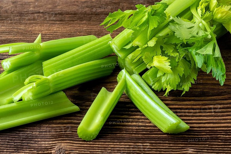Cut celery sticks and leaves on wooden table