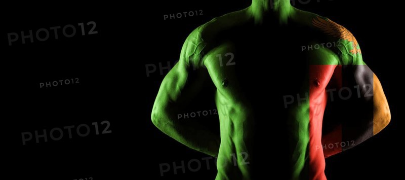 Zambia flag on muscled male torso with abs, black background