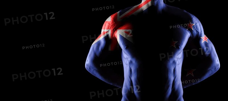New Zealand flag on muscled male torso with abs, black background
