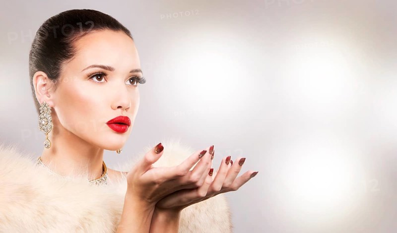 Upscale woman wearing gold jewellery and red lipstick on light background, Toronto, Canada, North America