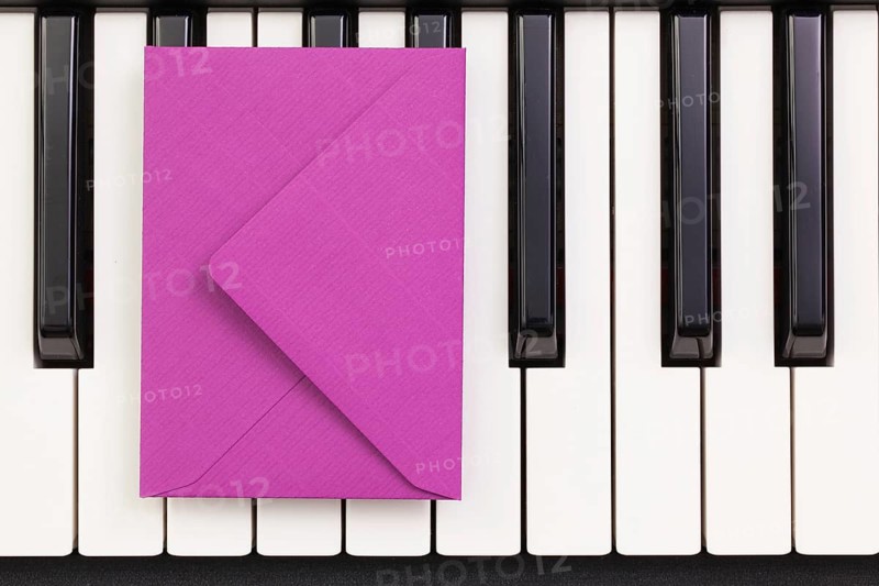 Funny arrangement envelope on the piano keybords - Flat lay image