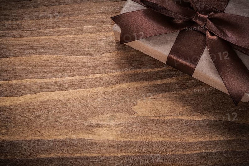 Packed present on vintage wooden board copy space holidays concept