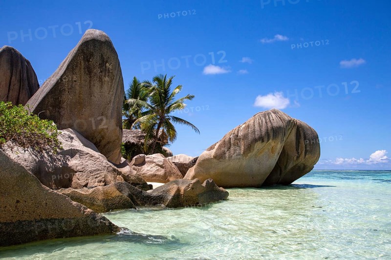 Paradise beach on La Digue with shallow sea and rocks