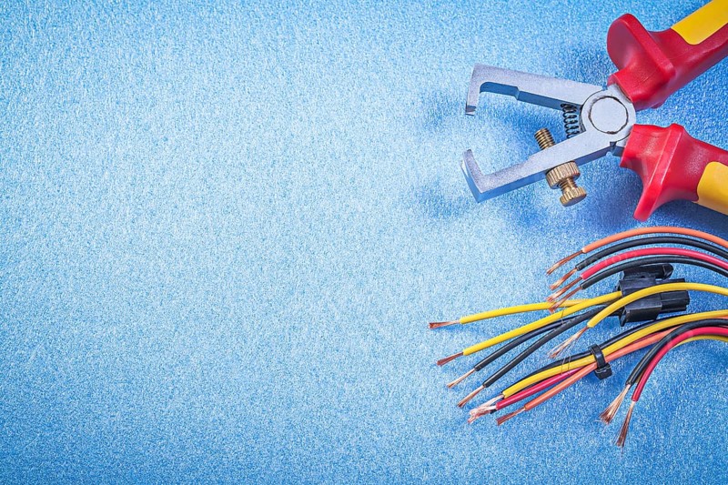 Insulated wire strippers electrical cables on blue background copy space electricity concept
