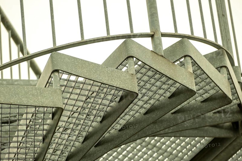 Details of a metal spiral staircase in an industrial building