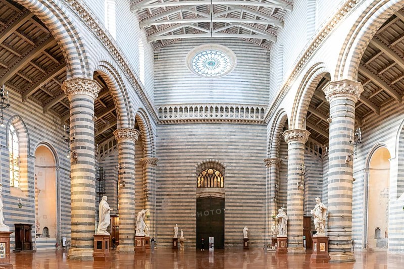 Orvieto, Italy, 18 November, 2023: interior view of the Orvieto Cathedral central nave with pews and many statues, Europe