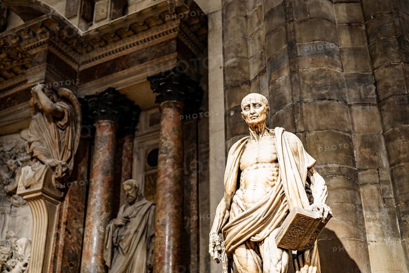 Statue of Saint Bartholomew with a book in his hands in the Duomo. Italy, Milan.