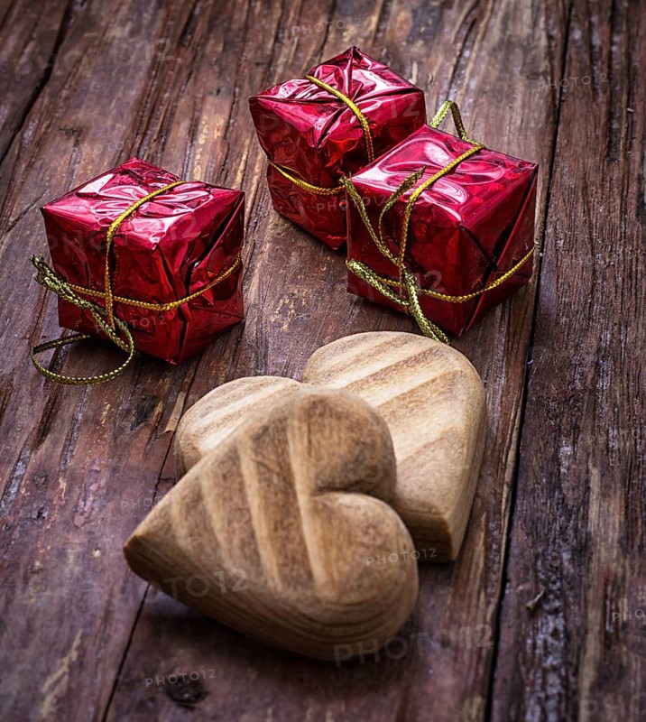 Hand-carved symbolic wooden heart on a background of yellow roses