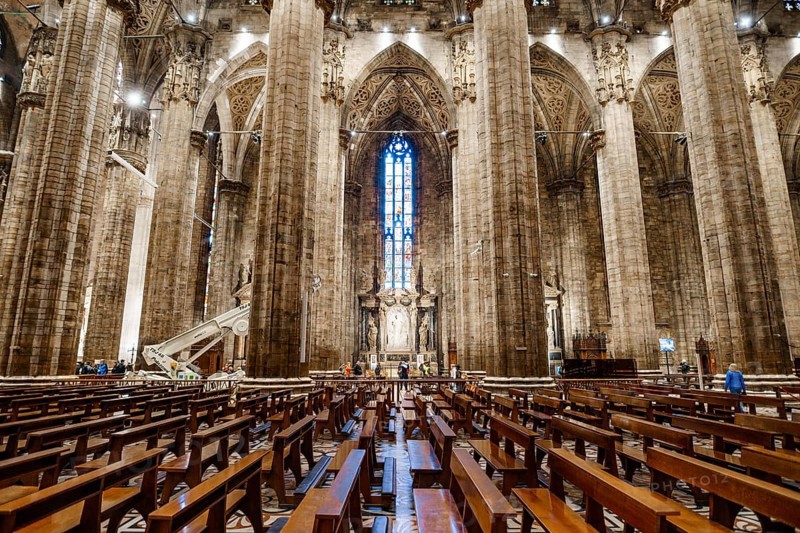 Rows of seats against the backdrop of columns in the Duomo. Italy, Milan.