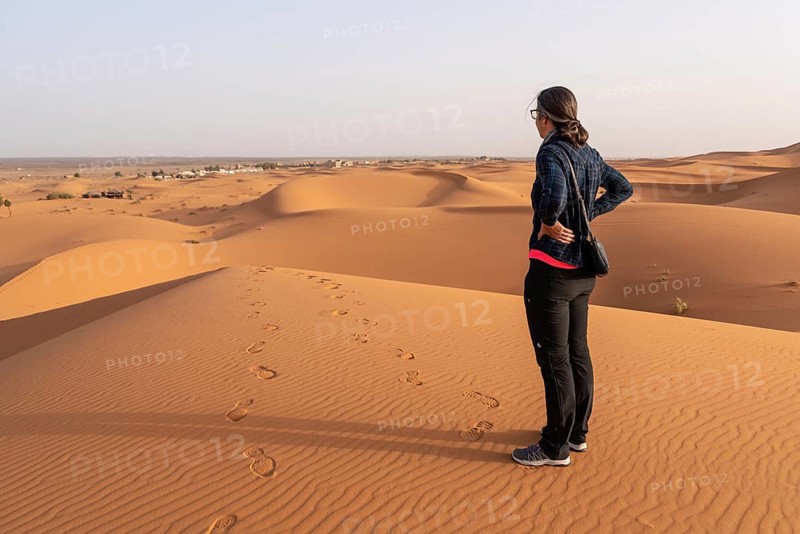 A person walking through the Erg Chebbi desert in the African Sahara, Morocco, Africa