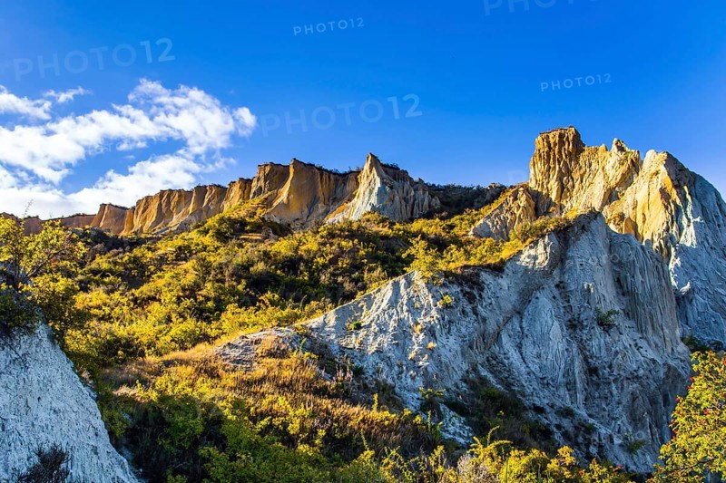 Fabulous country of New Zealand. Travel to the South Island. Warm sunny day. High white Clay cliffs with sharp peaks at sunset. The concept of eco, active, exotic and phototourism