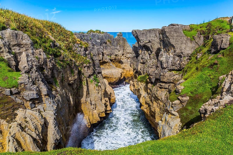 Picturesque coast of the South Island of New Zealand. Pancake rocks form narrow bays and fjords. The concept of photo and ecological tourism