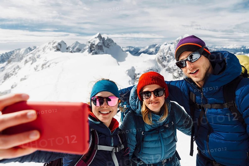 Mountaineer backcountry ski touring in the mountains. Ski touring in high alpine landscape with snowy trees. Adventure winter extreme sport.