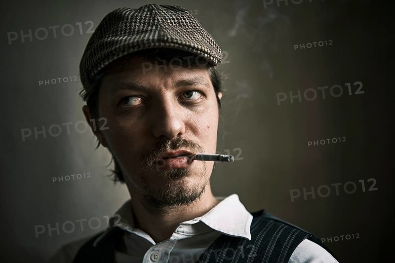 Young guy smoking cigarette, blows smoke, dressed in a retro style, in a beret, cinematic shot, big closeup